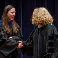 Provost shaking hands with faculty member